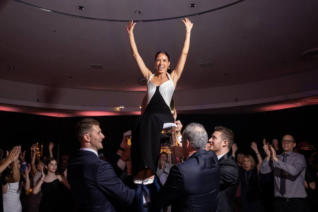 Guest lifted on shoulders during the hora with arms raised high