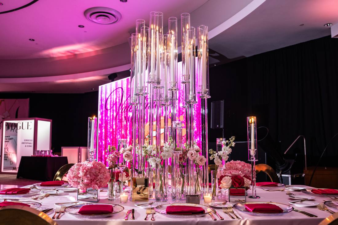 Reception table with tall crystal candle towers and pink floral arrangements